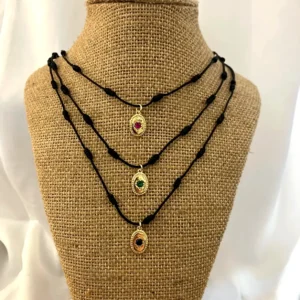 Collar Sweet con colgante de cristal en cordón ajustable sobre expositor de tela