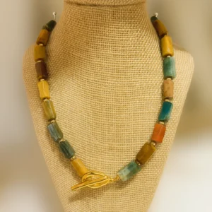 Collar Jaspe con cuentas rectangulares de piedra natural y cierre dorado sobre expositor de tela