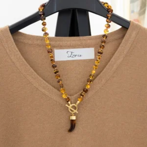 Collar Rob de acero y resina Mariposazul en tonos ámbar sobre prenda beige